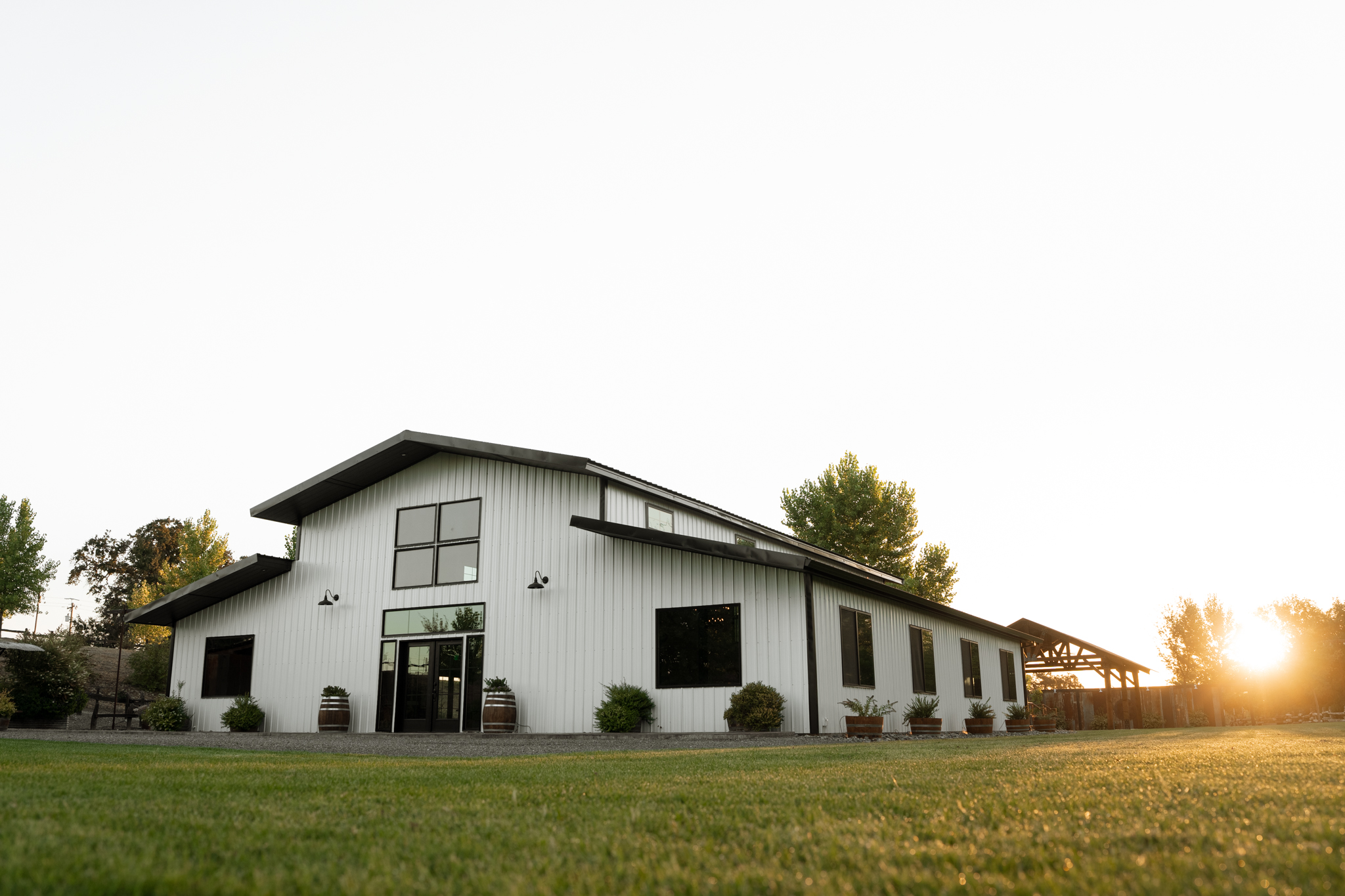 The white barn at golden hour with the lawn in front